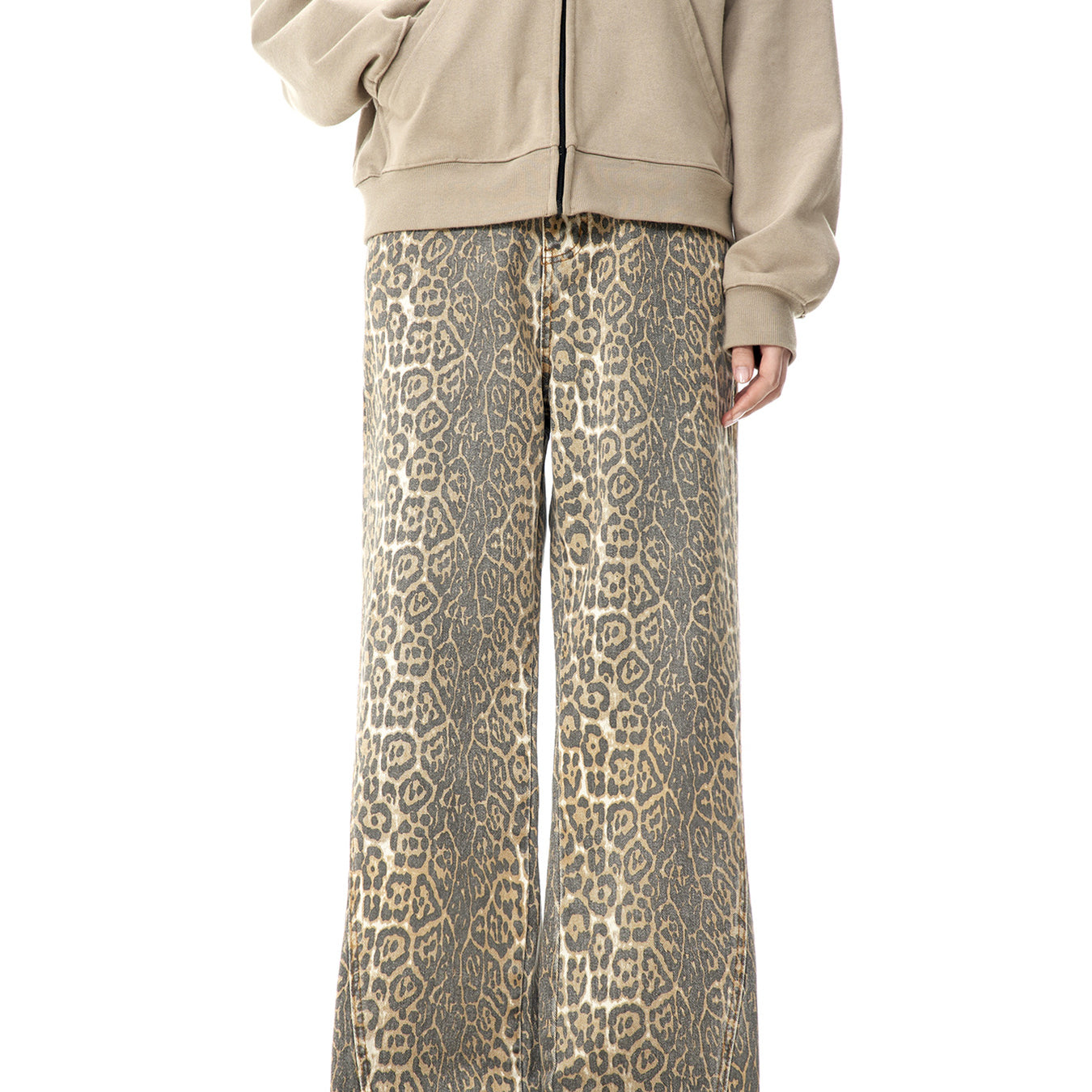 A model wearing beige zip-up hoodie and leopard print wide-leg pants standing against white background, showing full-length outfit view