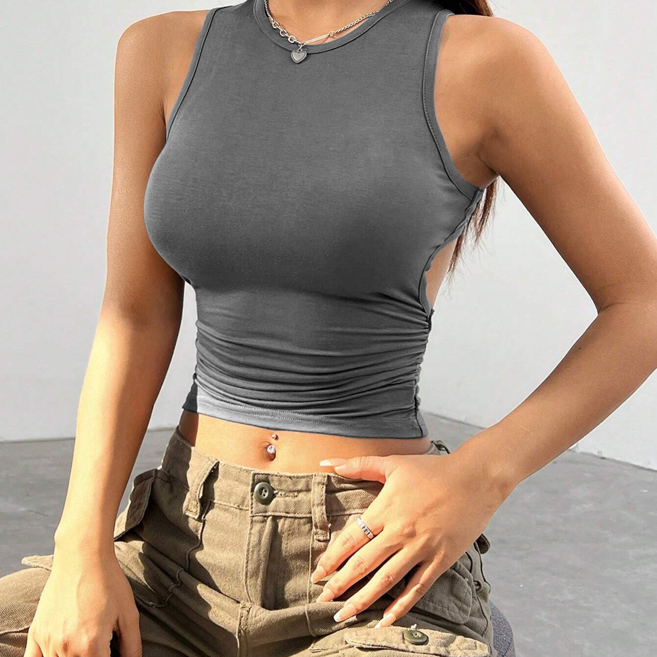 Gray sleeveless crop top with ruched waist, paired with khaki cargo pants, showcasing modern streetwear style