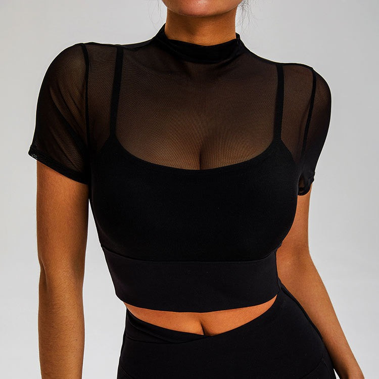Model in black athletic set featuring sheer mock neck overlay and sports bra with matching high-waist leggings
