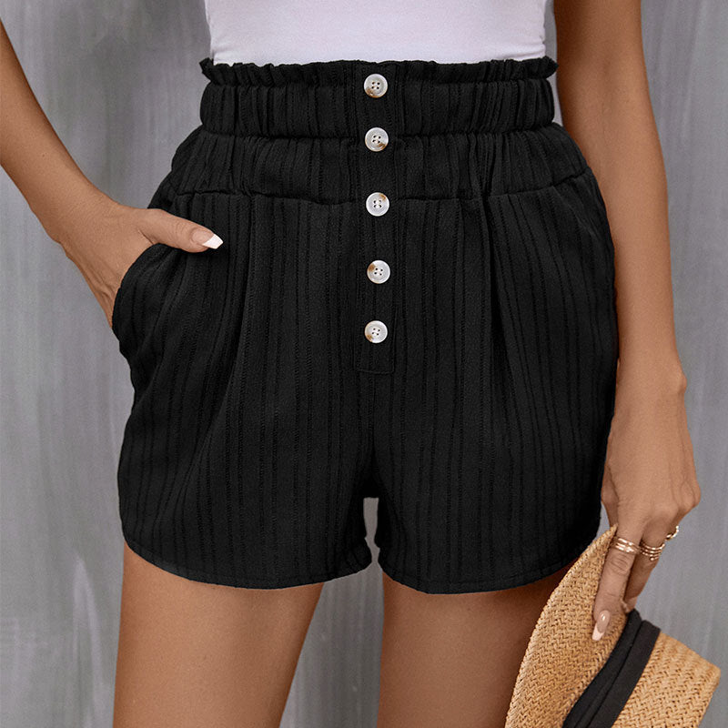 Black textured shorts with paperbag waist, white button detail and side pockets, shown against light gray backdrop
