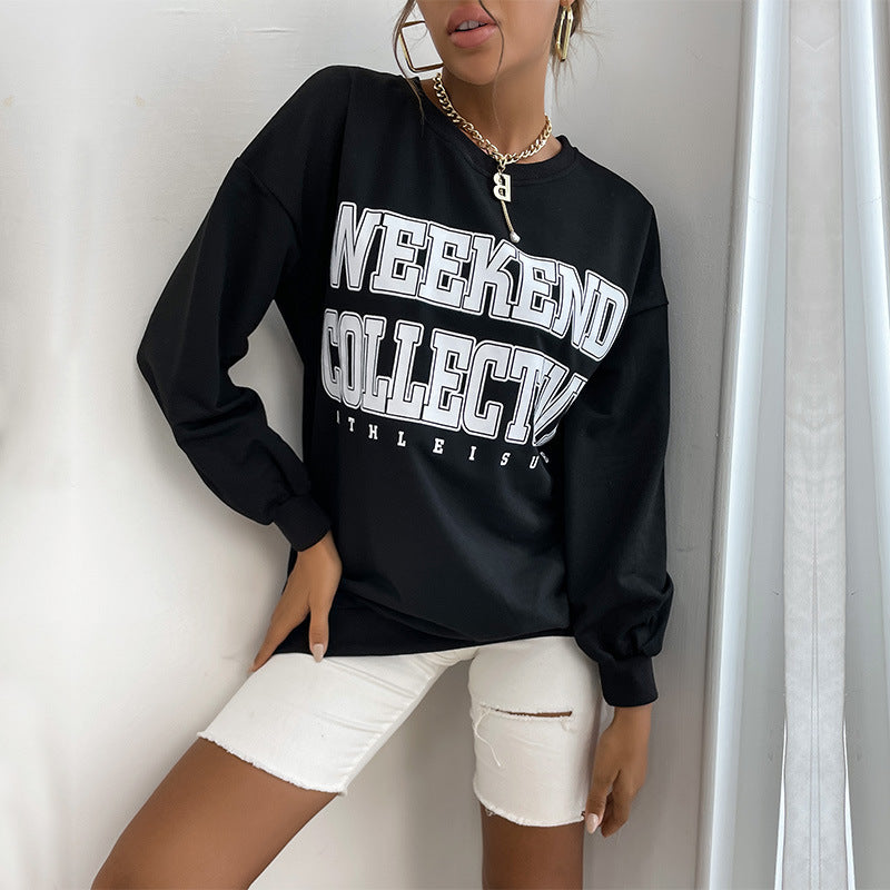 Woman wearing oversized black "Weekend Collective" sweatshirt with white distressed denim shorts and gold jewelry