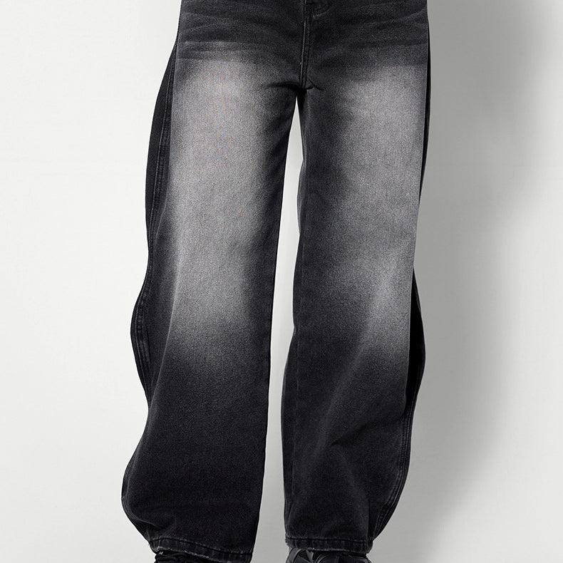 Wide-leg black washed denim jeans in relaxed fit, styled with gray tee and chunky black sneakers against white backdrop
