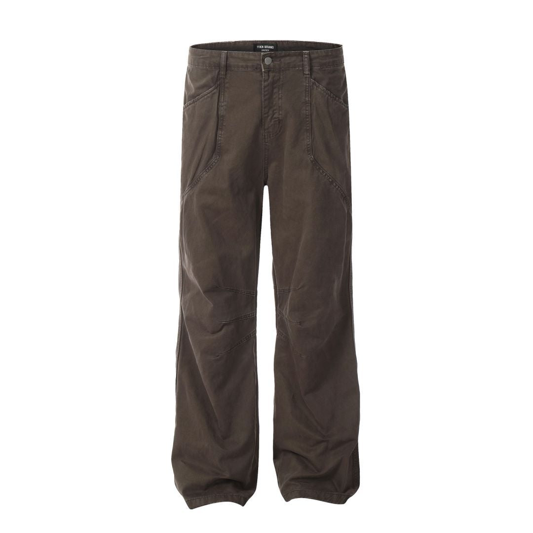Front view of ITKN dark brown wide-leg pants featuring curved panel design and utility details on white backdrop