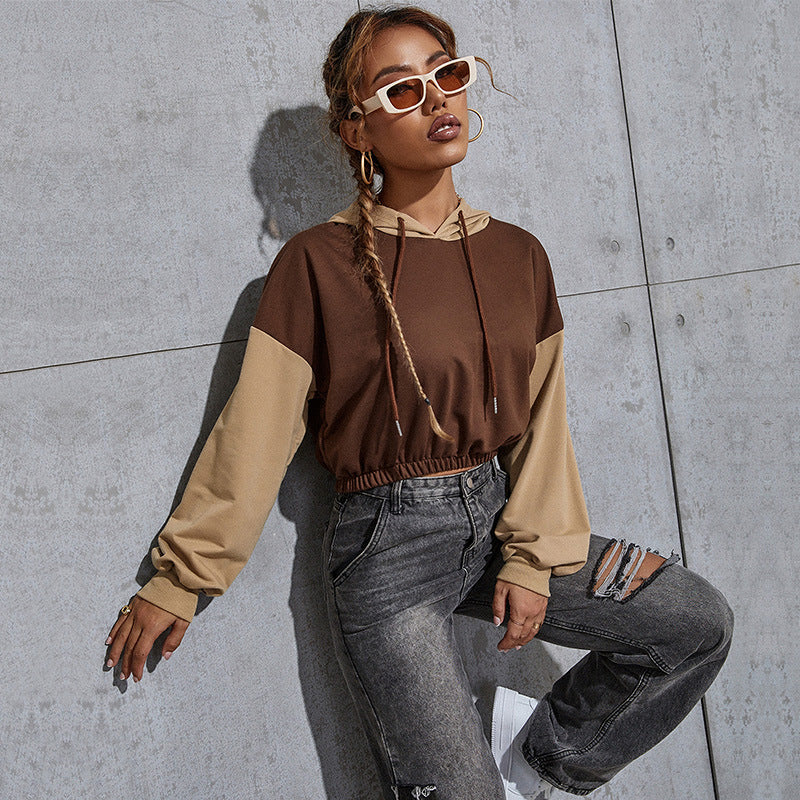 Brown hoodie, white sunglasses, braided hair, ripped jeans, industrial concrete setting