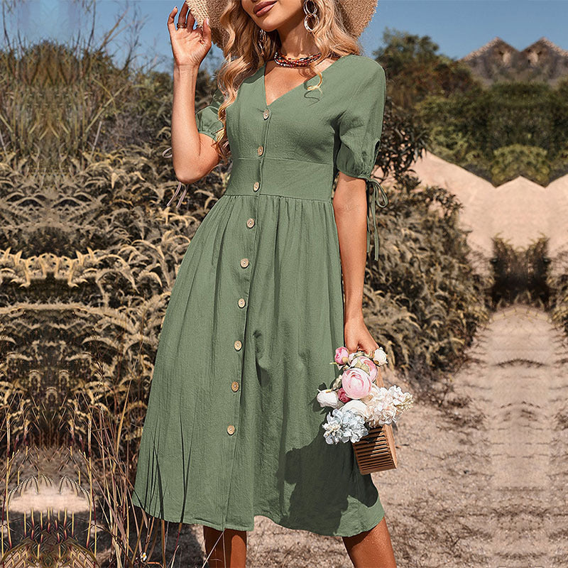 Sage green button-down midi dress with short sleeves, woman holding flower basket in grassy environment