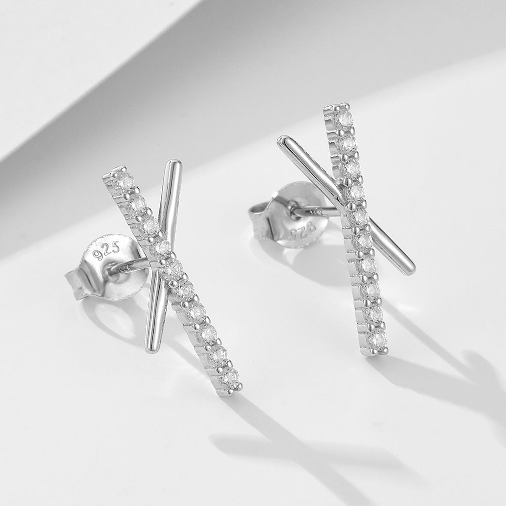 Silver 925 criss-cross stud earrings with cubic zirconia stones on one bar displayed against white background