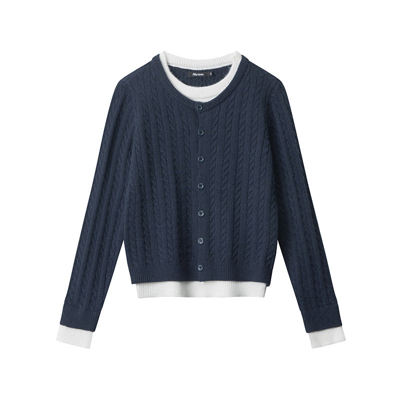 Navy cable knit cardigan with white trimmed crew neck, button-front closure, and contrast white layered hem. Ribbed details at edges. Front view.