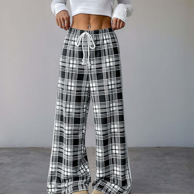 High-waisted plaid wide-leg pants with a relaxed fit and an adjustable drawstring waistband, styled with a white fitted crop top.