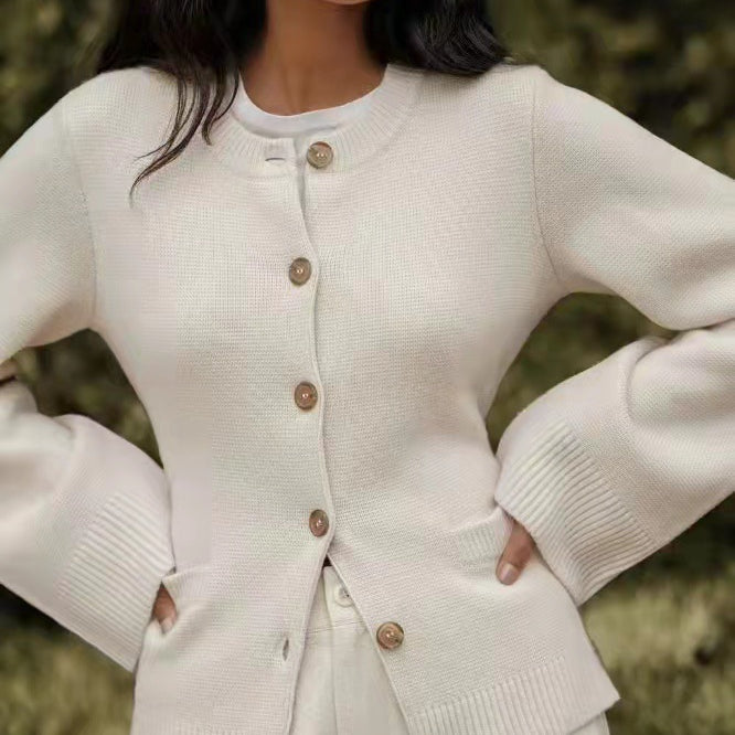 Beige buttoned cardigan sweater with round neckline, model posing outdoors with natural background