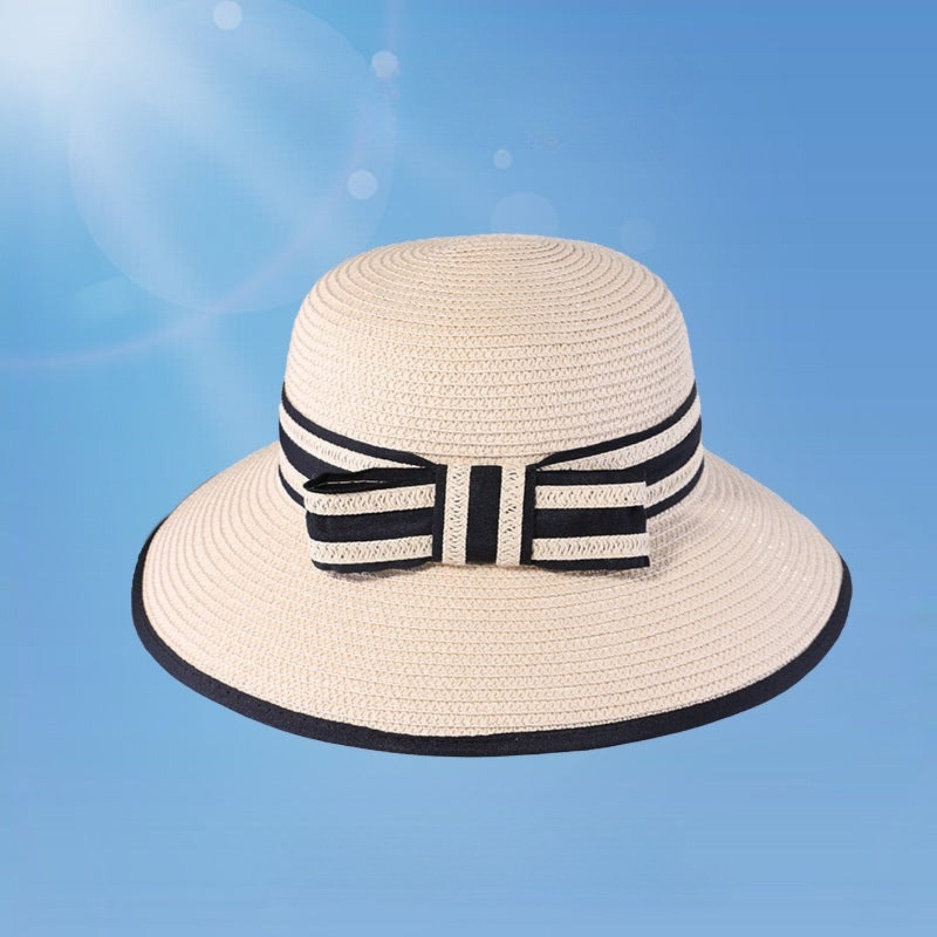 A beige woven sun hat with a black and white striped ribbon bow, set against a blue background.