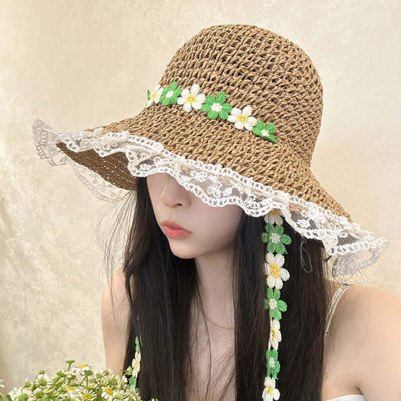 Side profile of a woman in a khaki woven sun hat with lace edges and green floral embroidery, slightly covering her face.