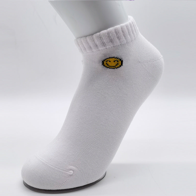 Close-up of white cotton ankle sock with yellow smiley face embroidery detail