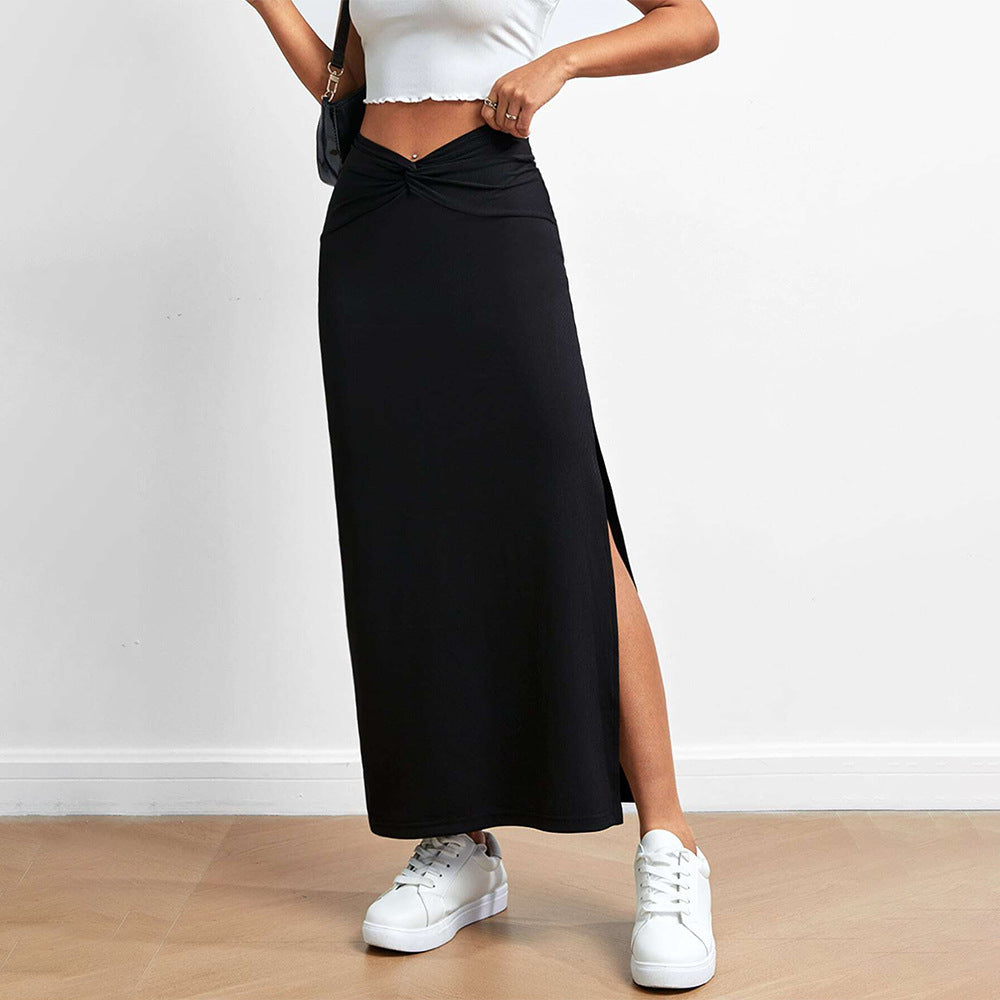 Black long skirt with V-shaped twisted waistband and side slit, paired with white sneakers and a hint of a white top