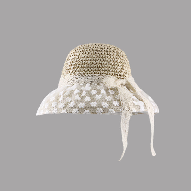 A beige straw sun hat with floral lace brim, lace ribbon tie, and delicate crochet band, displayed against a gray background.