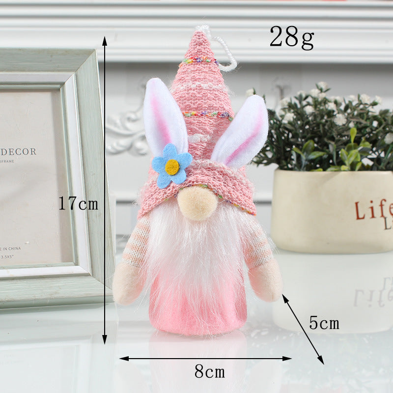 A pink Easter gnome with bunny ears, a floral hat, and a glowing body, measuring 17cm tall, placed on a decorative surface.
