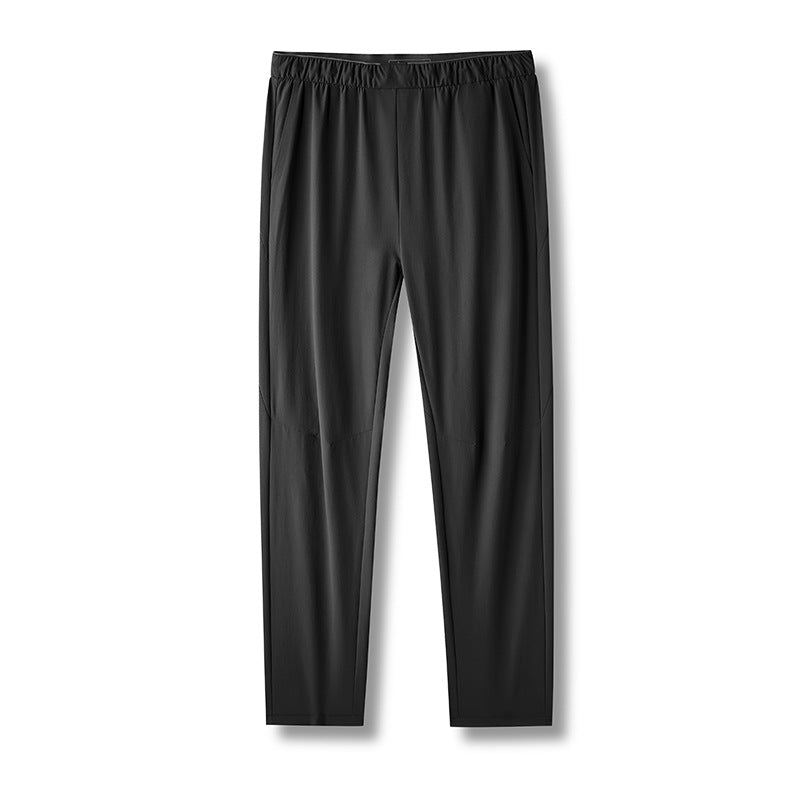 Full-length product shot of black hiking pants with elastic waistband laid flat against white background