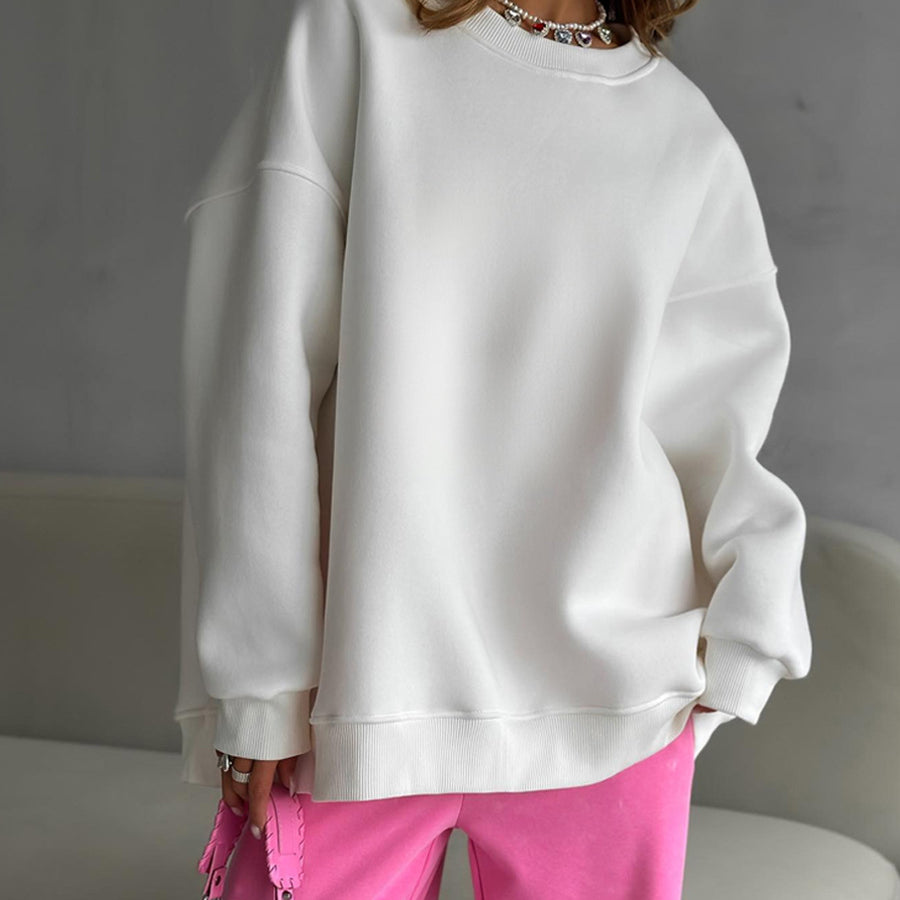 White oversized sweatshirt with pink pants – Model wears a loose-fit white sweatshirt styled with pink pants and a silver necklace