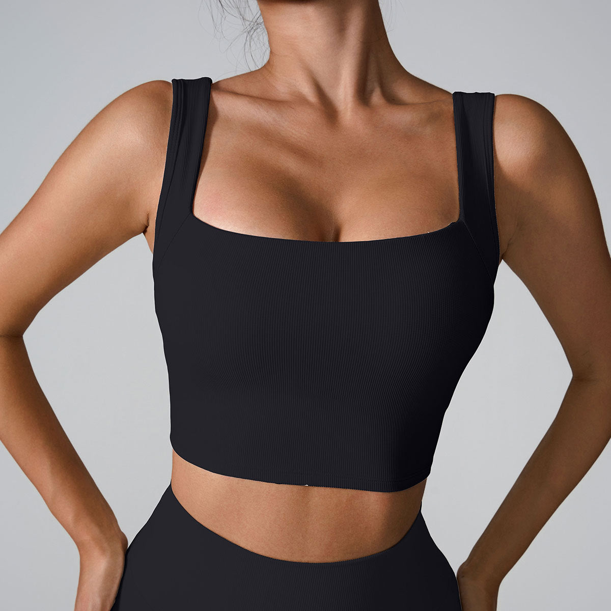 Black ribbed sports bra with wide square neckline and matching high-waisted bottoms
