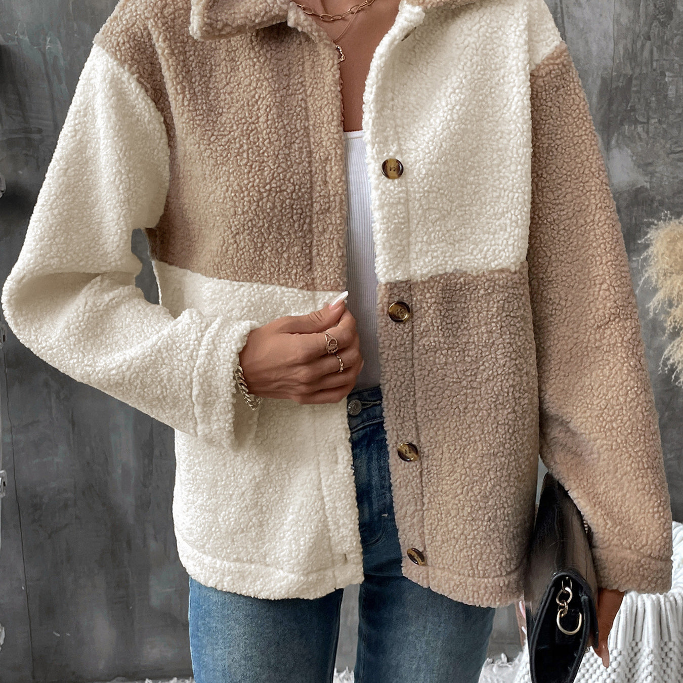 Two-tone beige and cream sherpa jacket with button front over white tank top and jeans