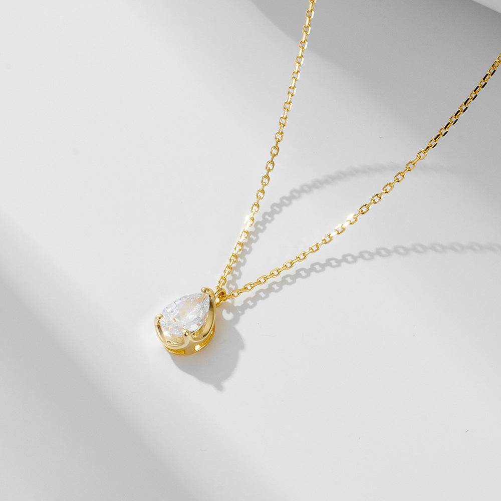 Gold chain necklace with teardrop-cut CZ pendant on white background.