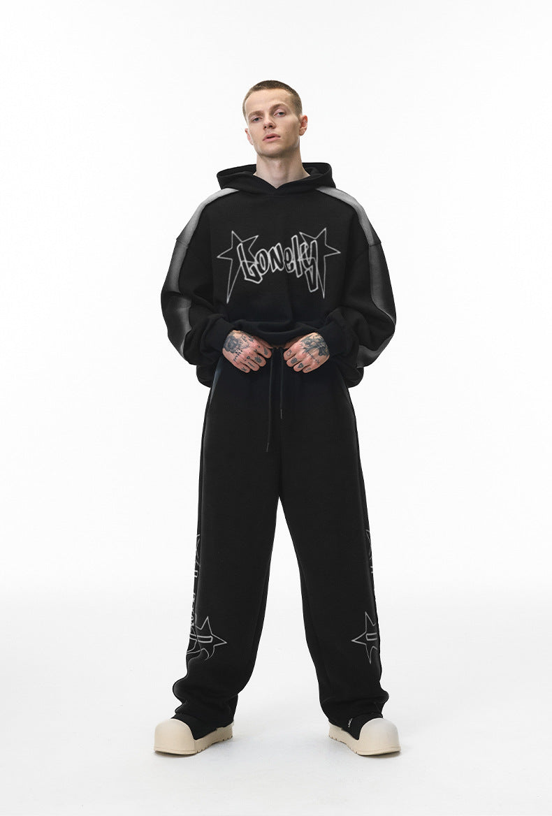 Front stance—men’s black drawstring baggy sweatpants, relaxed straight leg.