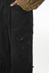 Black cargo pants close-up of side cargo pocket with flap and rivet