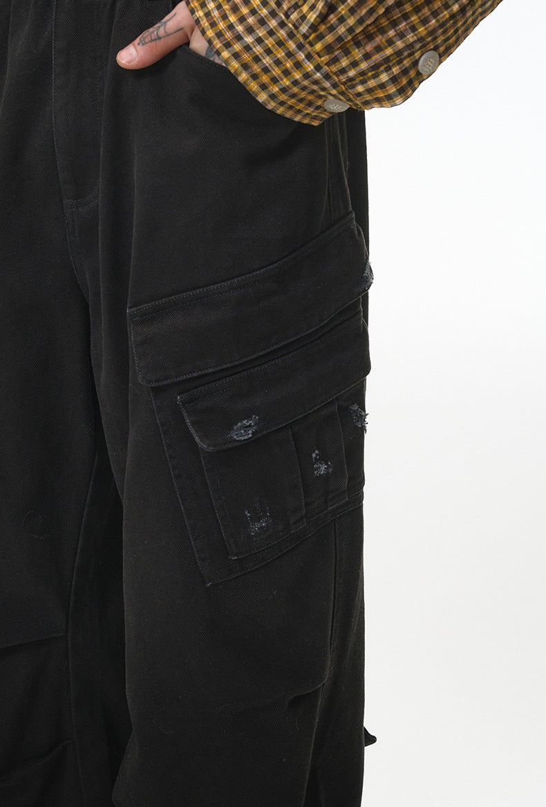 Black cargo pants close-up of side cargo pocket with flap and rivet
