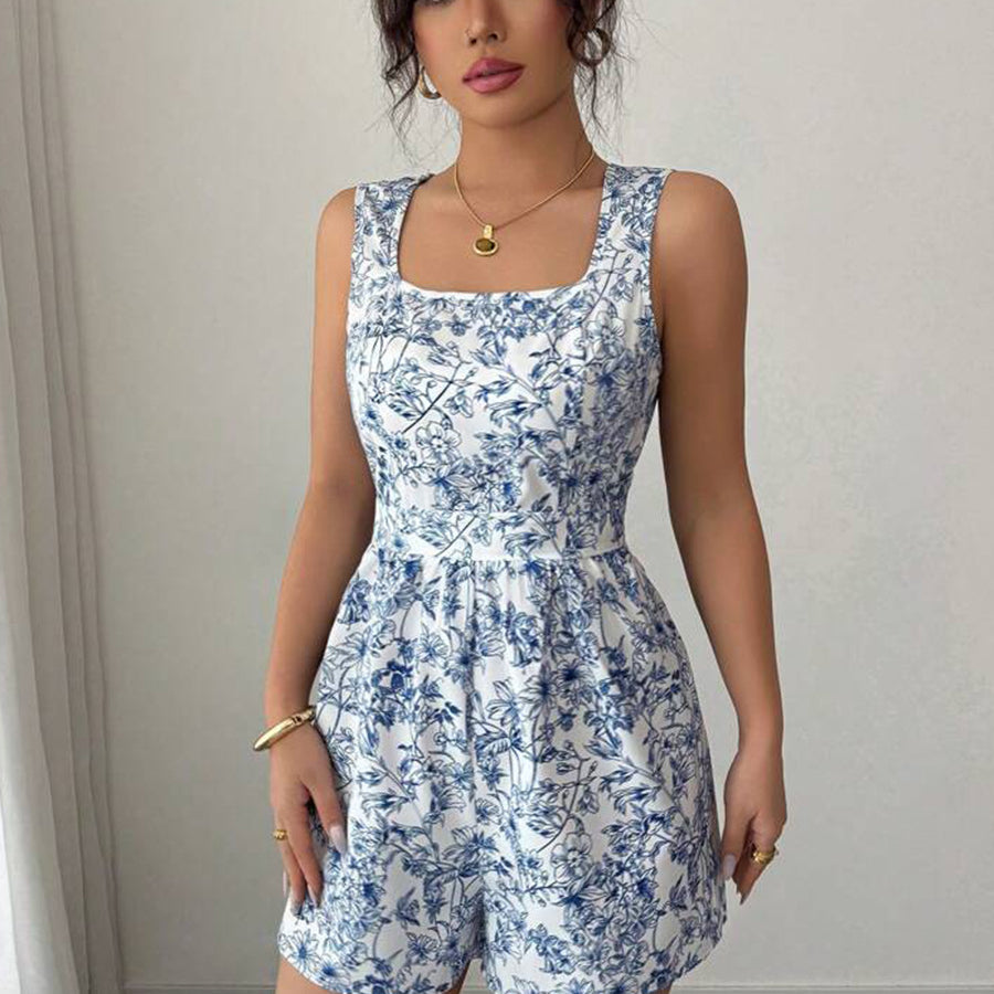 Woman wearing a blue floral romper against a plain background