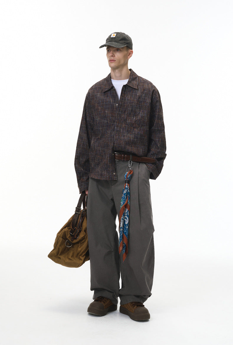 Model in charcoal corduroy pants with plaid shirt, relaxed street fit