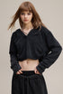 Black cropped hoodie, front view—drop shoulder and rib cuffs.