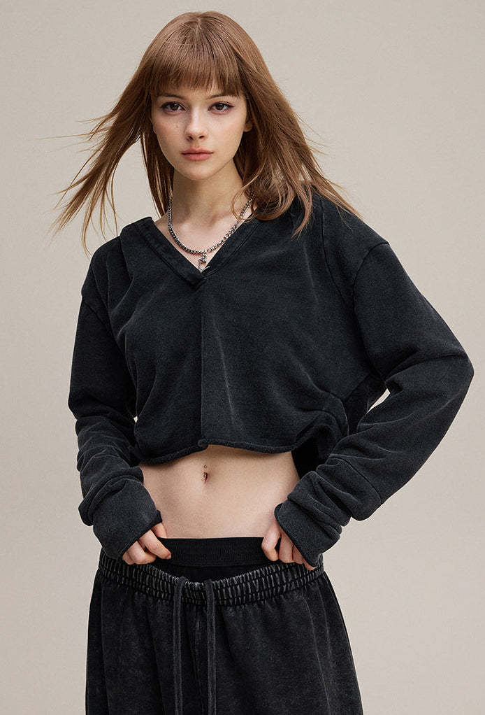 Black cropped hoodie, front view—drop shoulder and rib cuffs.