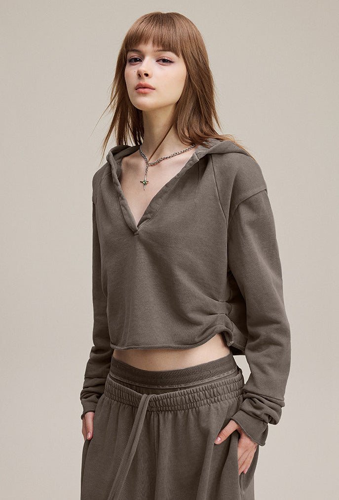Brown cropped hoodie, side view—streetwear crop with raw hem.