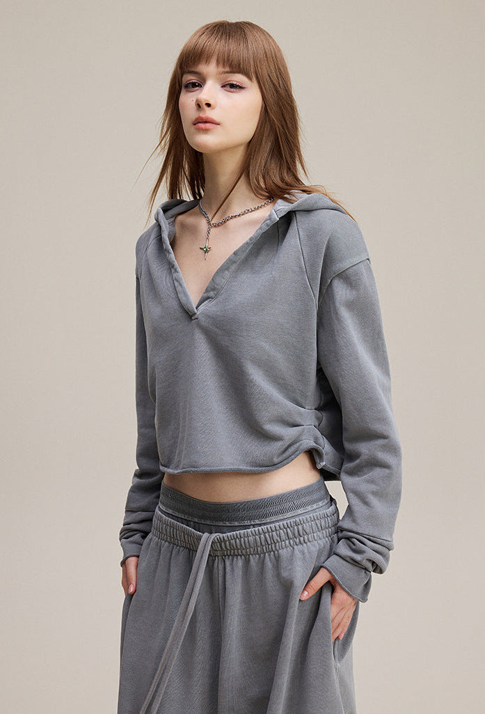 Light gray cropped hoodie, side view—relaxed fit, rib cuffs, clean zipless front.