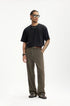 Model in dark brown mens dress pants paired with black shirt and sunglasses