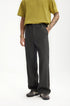 Model in dark gray mens dress pants with yellow polo shirt front view