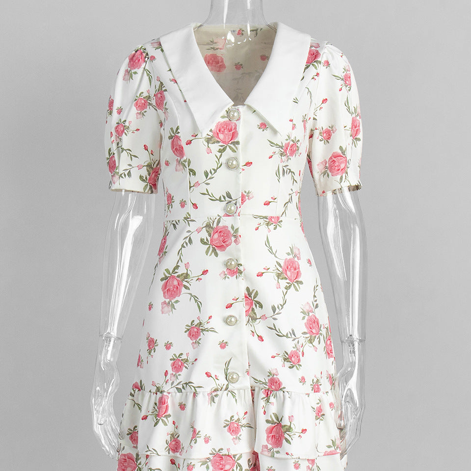White floral dress with puff sleeves and tiered hem on clear mannequin.
