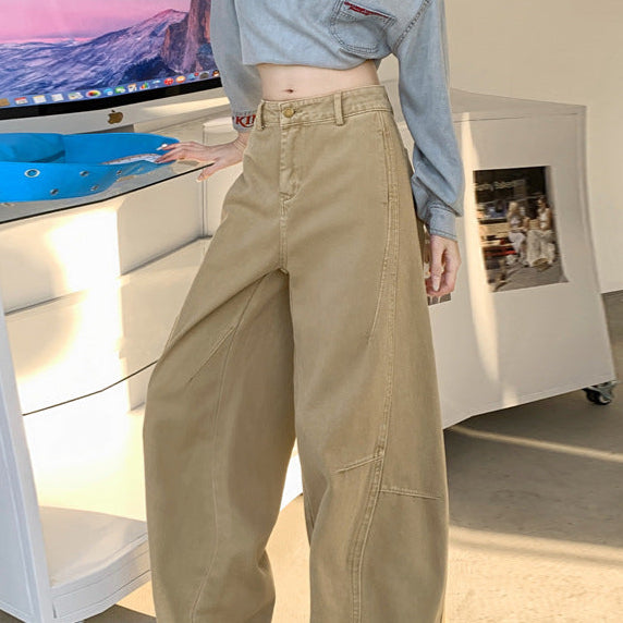 Side angle of khaki wide-leg jeans styled with off-shoulder denim top indoors.
