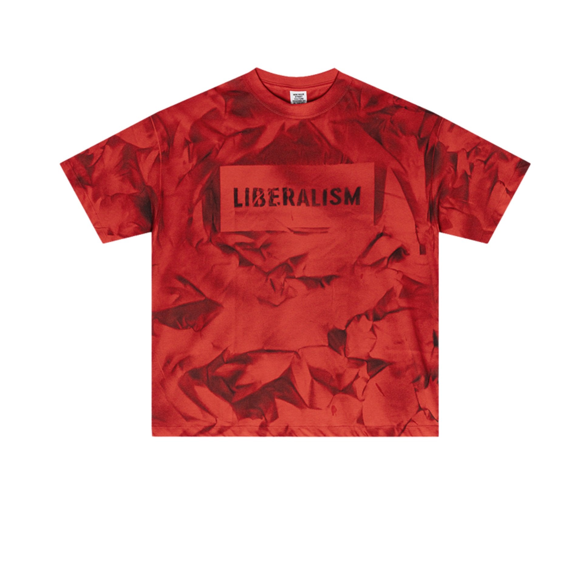 Flat lay of red graphic tee with black “LIBERALISM” stencil text over abstract crumpled print.