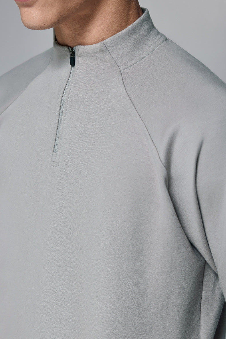 Close-up of a light gray half zip long sleeve tshirt on a plain background