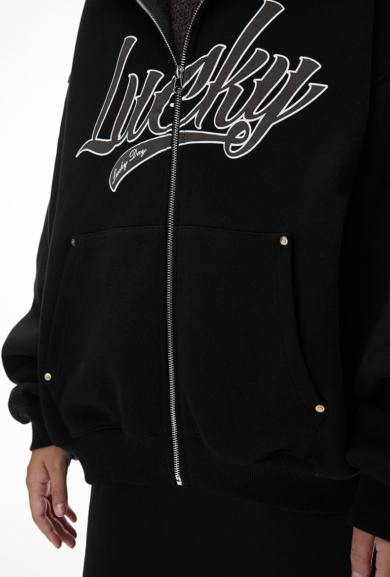 Embroidered “Lucky” logo on black jacket, chest close-up.