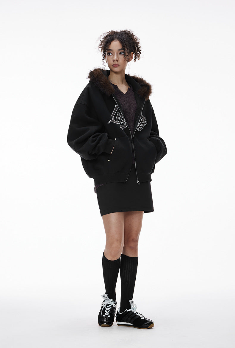 Female model in black fur-hood zip jacket with skirt, full body.