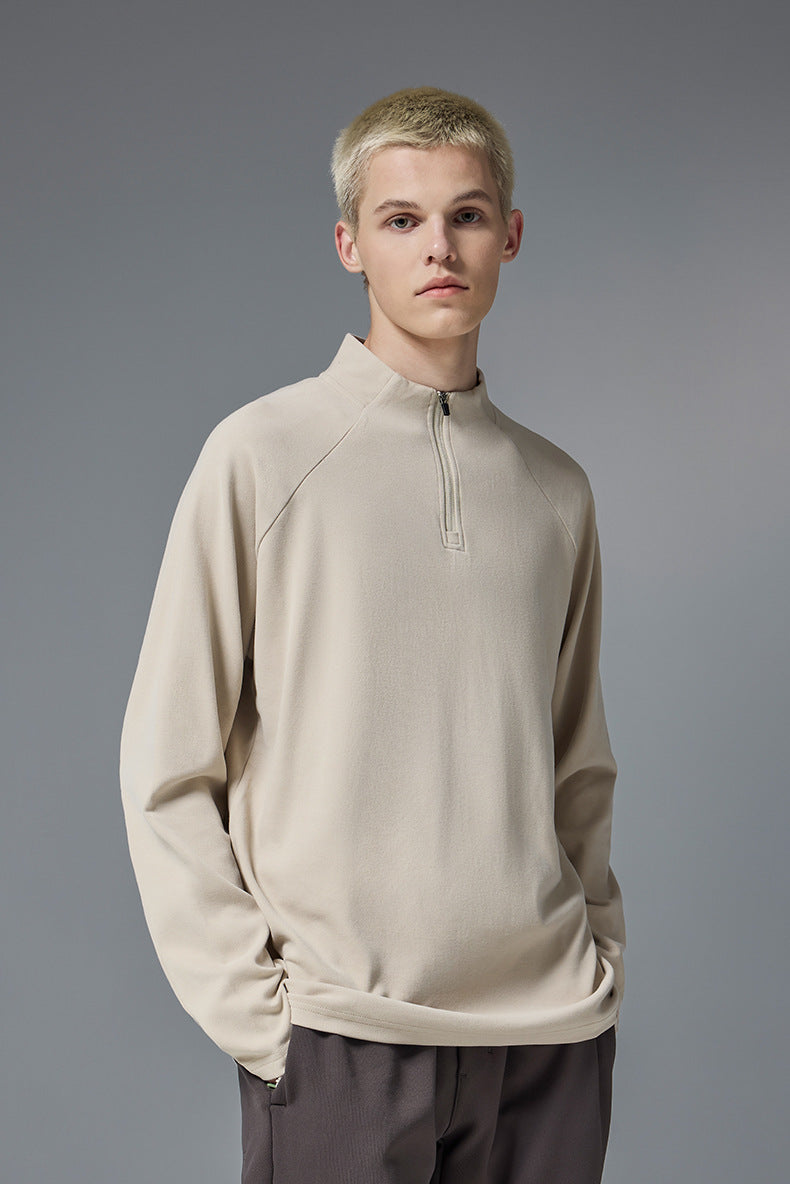 Man wearing khaki half zip long sleeve t shirt styled with brown pants