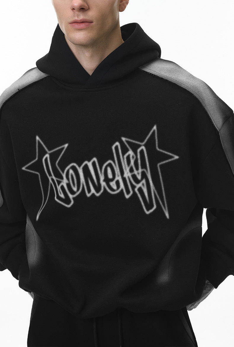 Male model close-crop in black hoodie showing chest logo and fit.