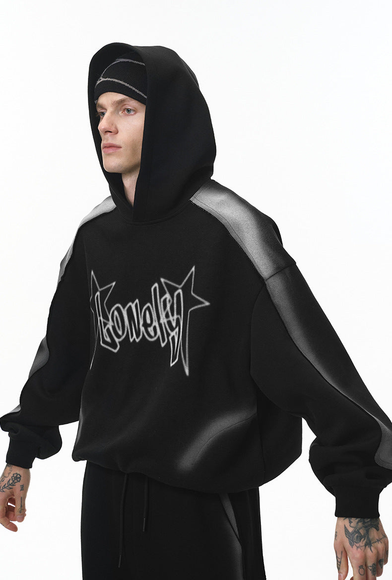 Three-quarter view of black graphic hoodie on model, relaxed stance.