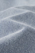 Close-up of textured light blue jeans fabric with a subtle pattern