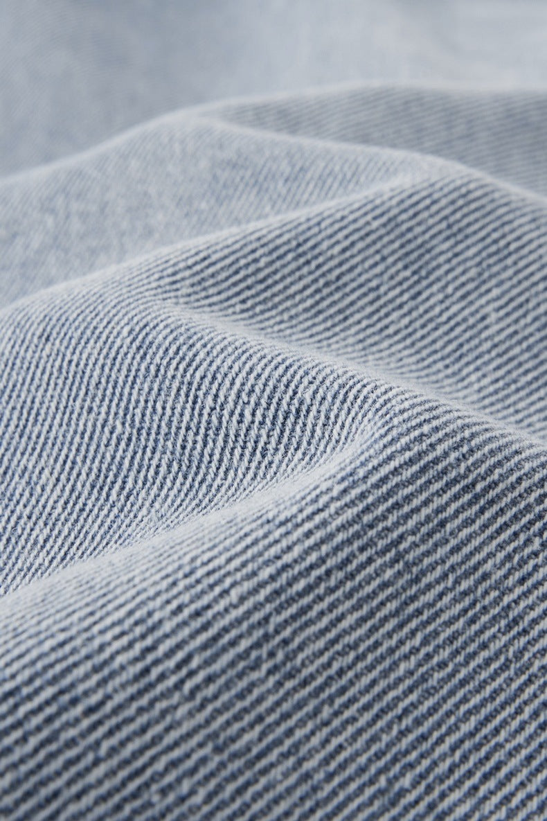 Close-up of textured light blue jeans fabric with a subtle pattern