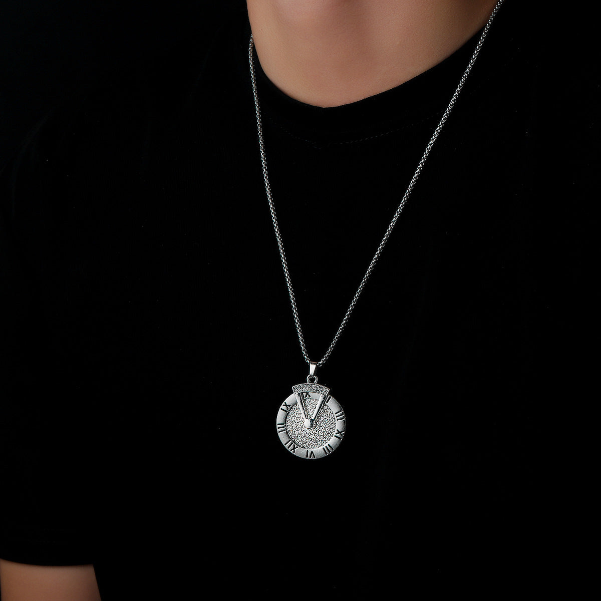 Roman clock necklace worn over black shirt for streetwear look.