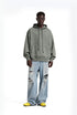 Person wearing sage hoodie and light blue jeans with a white background