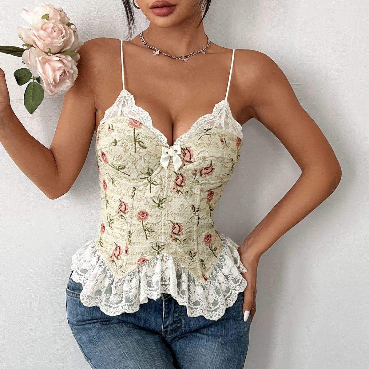 Front view of floral corset top with lace-up closure and lace hem, styled with denim.