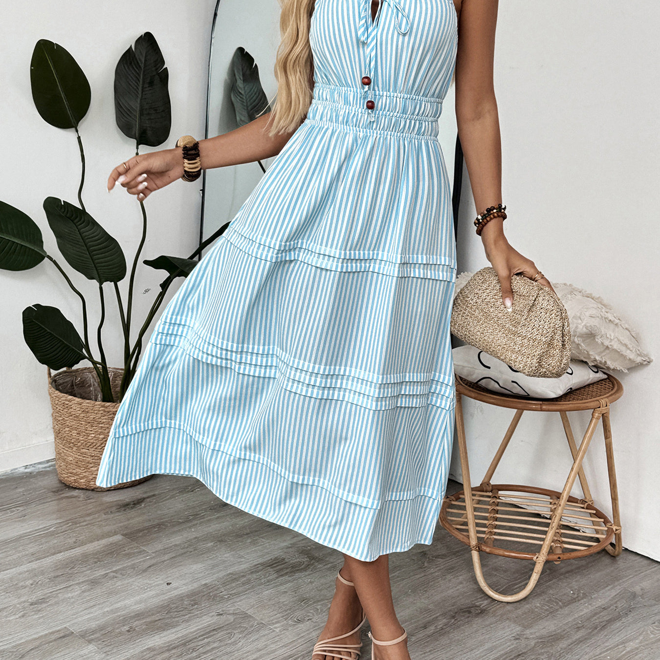 Spinning pose in striped cami dress with smocked waist and decorative buttons.